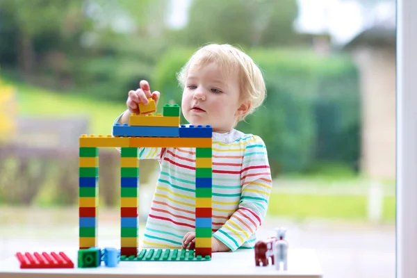 Ευχαρίστως toddler κορίτσι παίζει με πολύχρωμο μπλοκ στο εσωτερικό — Φωτογραφία Αρχείου