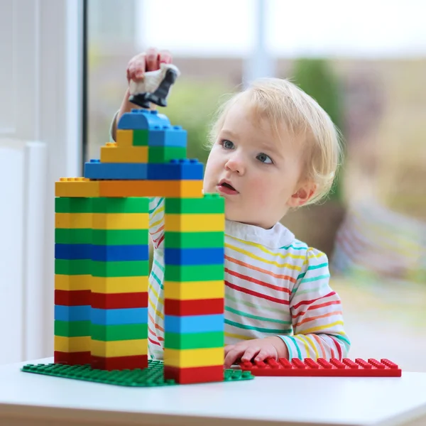 Happy toddler girl playing with colorful blocks indoors — Stock Photo, Image