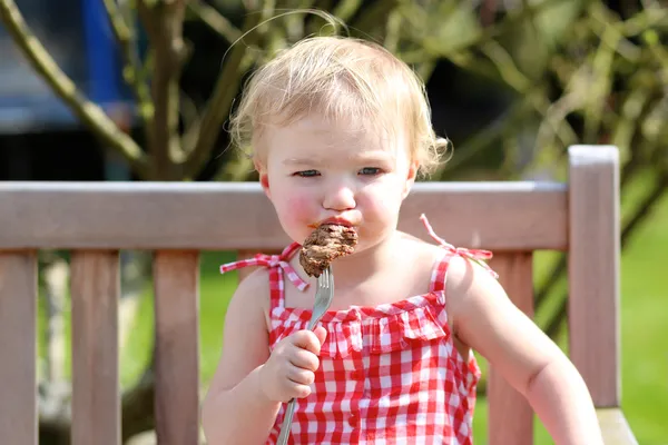 Niña comiendo carne — Foto de Stock