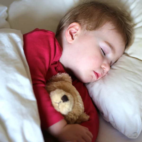 Niño durmiendo sosteniendo oso — Foto de Stock