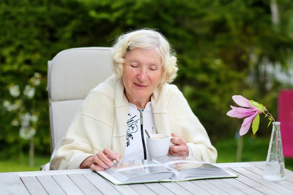 Seniorin sieht Bilder ihres Enkels — Stockfoto