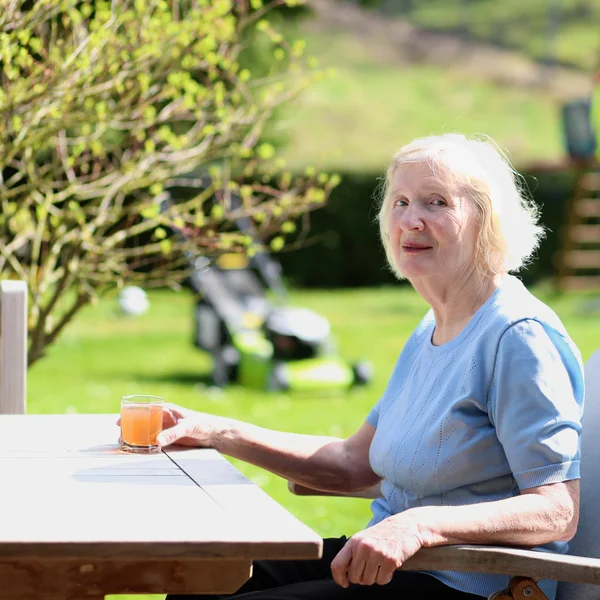 Gelukkig senior vrouw ontspannen in de zomertuin — Stockfoto