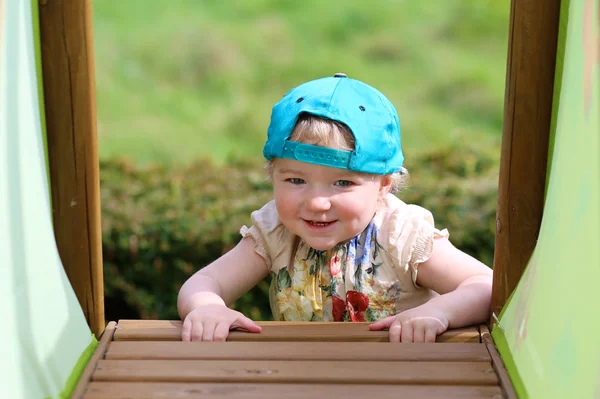 Happy little girl climbing on playground — Stock Photo, Image