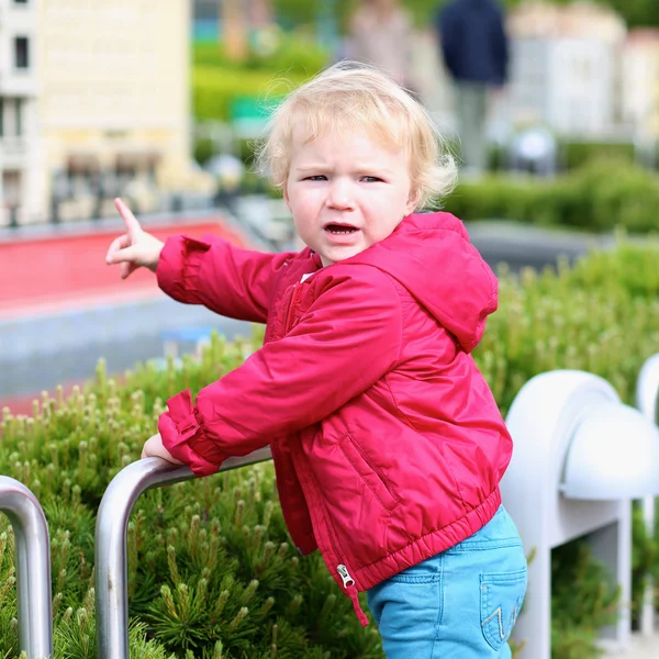 Little girl looks at miniature installations at amusement park — Stock Photo, Image