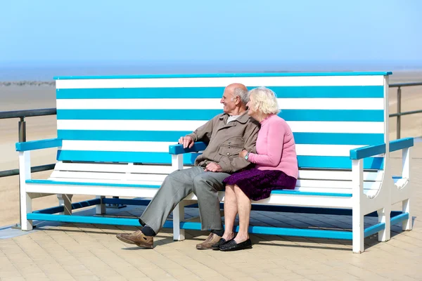 Mutlu bir son sınıf çift bankta oturan Promenade rahatlatıcı — Stok fotoğraf