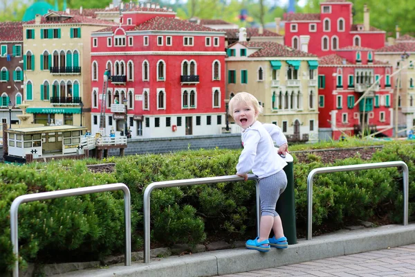Little girl looks at miniature installations at amusement park — Stock Photo, Image