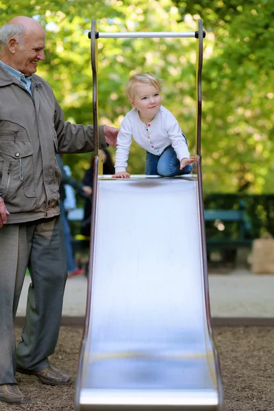 Grandfather with his granddaughter at the playground — Stock Photo, Image