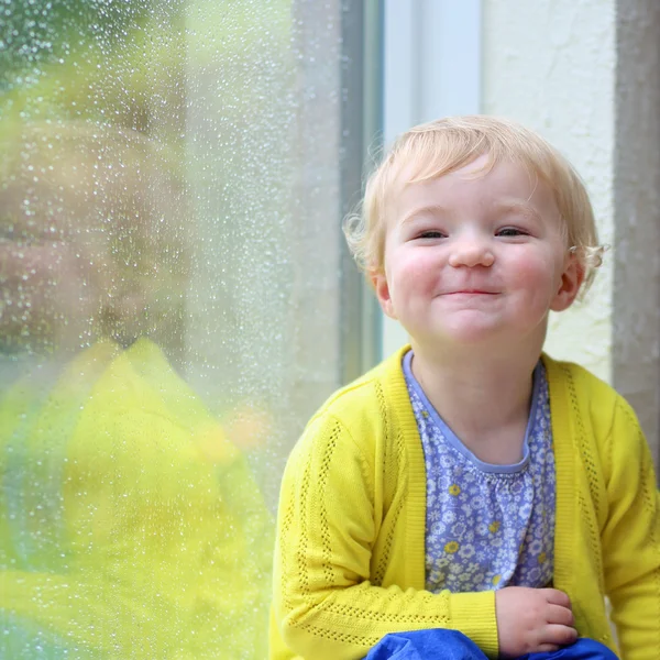 Kleines Kind blickt durch Fenster — Stockfoto