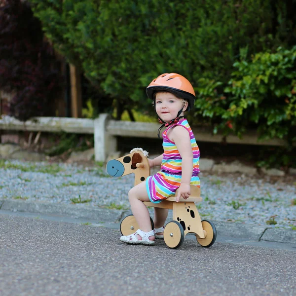 Niño feliz en casco de seguridad montar triciclo de madera — Foto de Stock