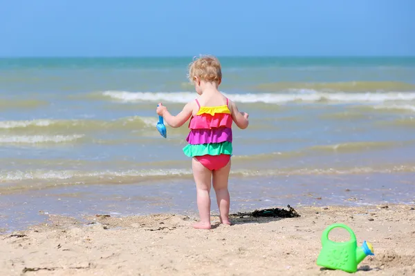 Kleines Mädchen baut Sandburgen am tropischen Strand — Stockfoto