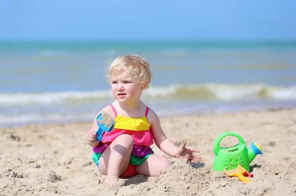 Liten flicka bygga sandslott på tropisk strand — Stockfoto