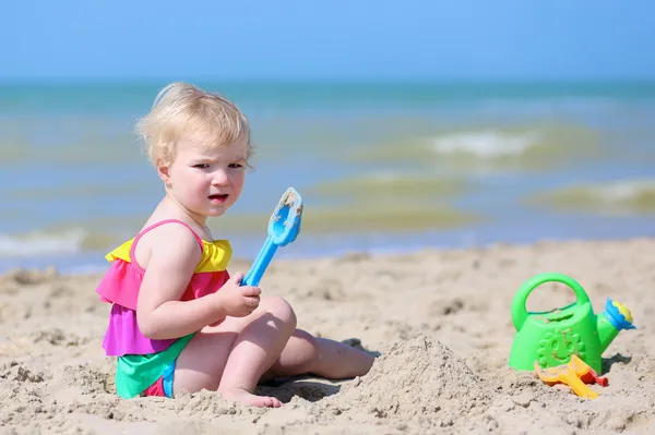 Liten flicka bygga sandslott på tropisk strand — Stockfoto