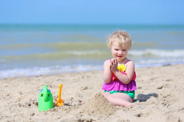 Niña construyendo castillos de arena en la playa tropical —  Fotos de Stock