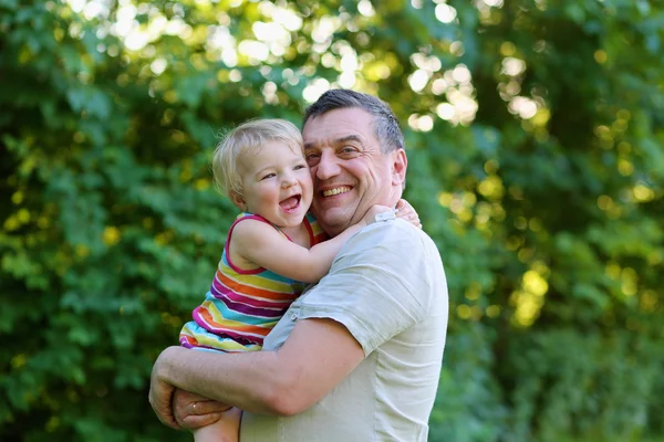 Feliz padre sosteniendo a su pequeña hija — Foto de Stock