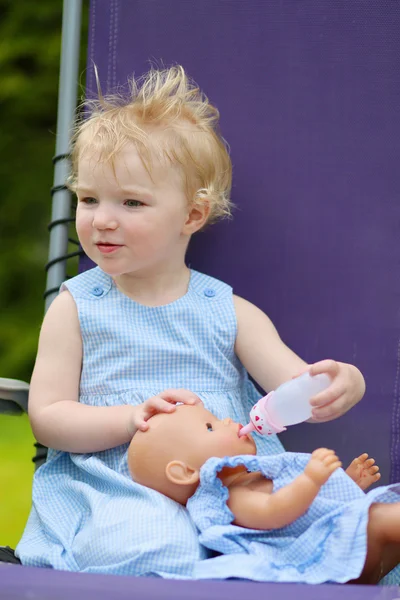 Little girl feeding her doll — Stock Photo, Image