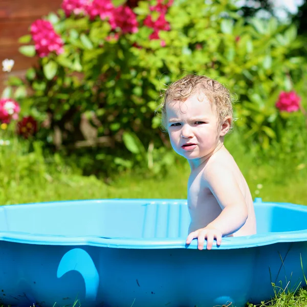 Niño feliz jugando con agua en baño de plástico en el jardín —  Fotos de Stock