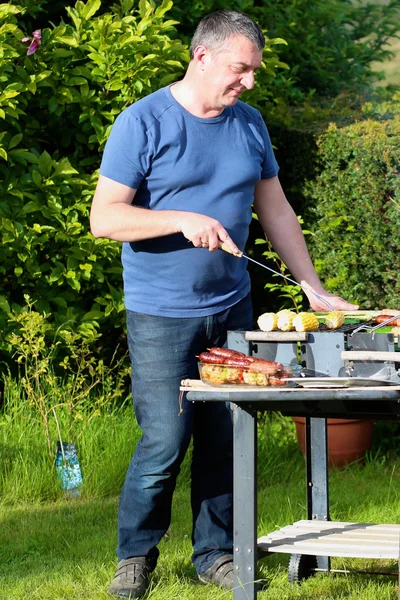 Een man voorbereiding van heerlijke geassorteerde vlees en groenten op barbecue grill — Stockfoto