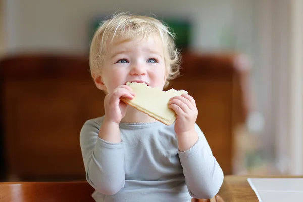 Lilla barn girl med smörgås till frukost — Stockfoto
