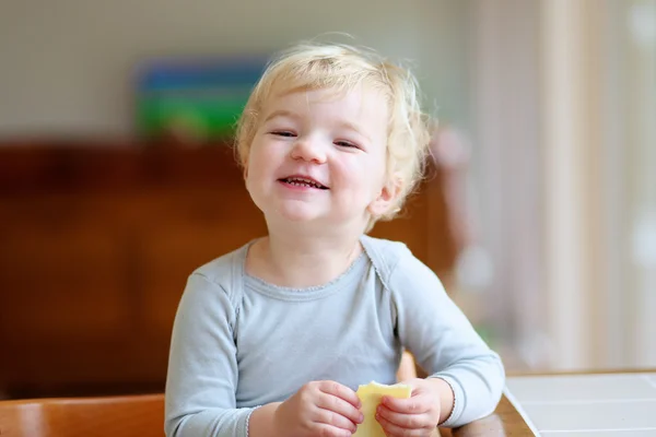 Pequeña niña tomando sándwich para desayunar — Foto de Stock
