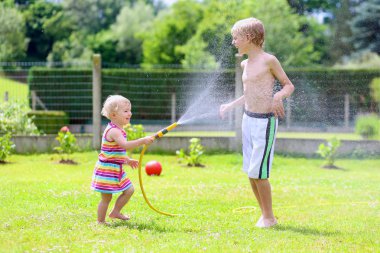 Bahçe Sulama hortumu ile oynarken kardeş