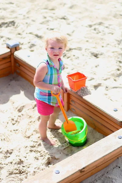 Little girl playing in sandbox — Stock Photo, Image