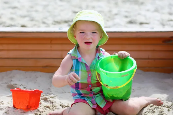 Little girl playing in sandbox — Stock Photo, Image