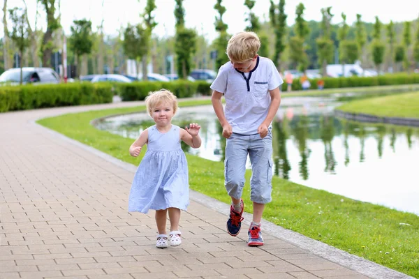 Niños felices corriendo juntos a lo largo del pequeño río —  Fotos de Stock