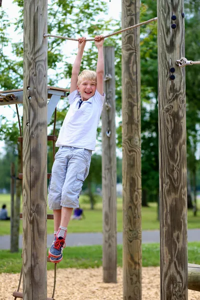 Felice adolescente ragazzo divertirsi sul parco giochi nel parco — Foto Stock