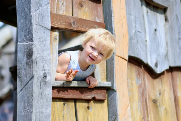 Petite fille drôle jouant dans la maison en bois — Photo