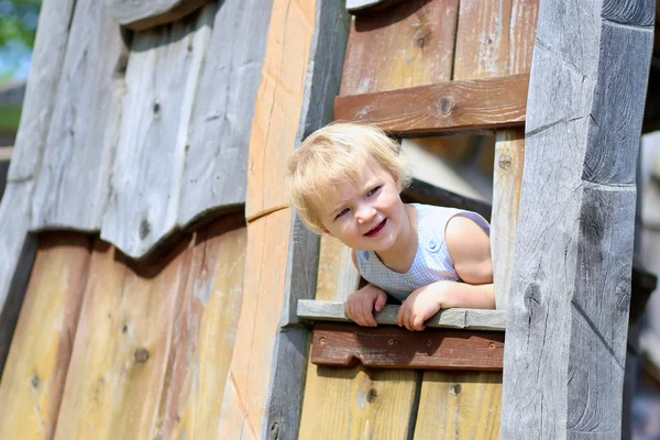 Petite fille drôle jouant dans la maison en bois — Photo