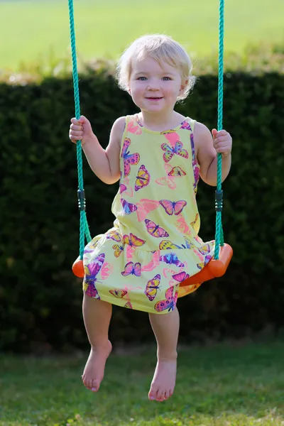 Boldog kis lány játszik, lóbálva, játszótéren — Stock Fotó