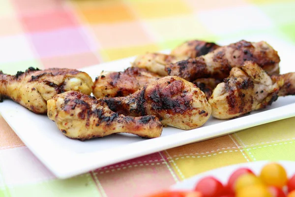 Delicious grilled chicken legs on picnic table — Stock Photo, Image