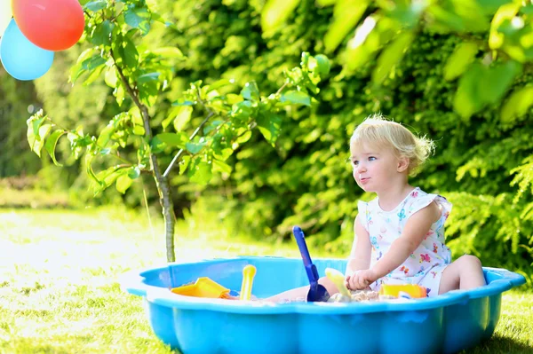 Menina feliz brincando com sandbox ao ar livre em um dia ensolarado de verão — Fotografia de Stock
