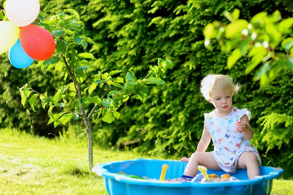 Gelukkig meisje spelen met sandbox buitenshuis op een zonnige zomerdag — Stockfoto