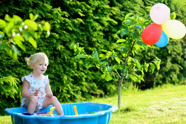 Boldog kis lány játék Sandbox a szabadban egy napsütéses nyári napon — Stock Fotó