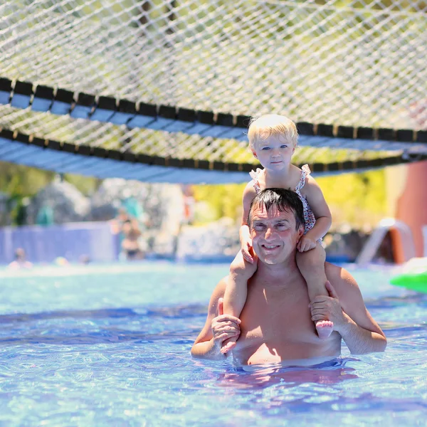 Father and daughter having fun in outdoors swimming pool — Stock Photo, Image