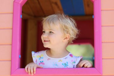 mutlu küçük kız eğleniyor playhouse içinde bir yaz gününde