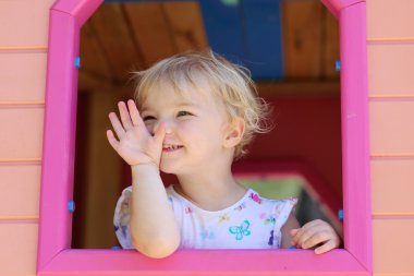 mutlu küçük kız eğleniyor playhouse içinde bir yaz gününde