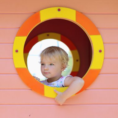 mutlu küçük kız eğleniyor playhouse içinde bir yaz gününde