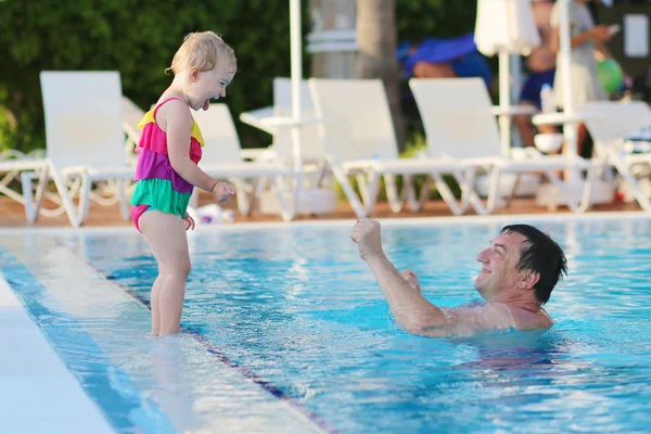 Father and daughter having fun in outdoors swimming pool — Stock Photo, Image