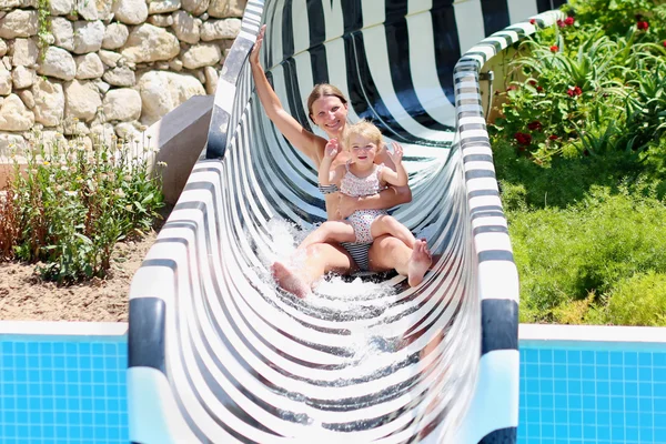 Matka i córka zabawy na slajdzie w aqua parku — Zdjęcie stockowe