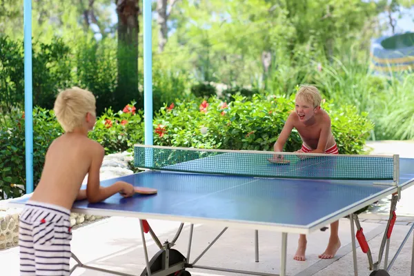 Deux garçons heureux jouant au ping-pong à l'extérieur — Photo