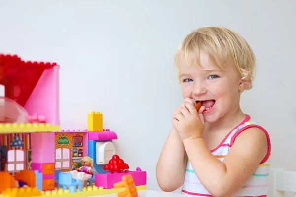 Casa de construção menina feliz de blocos de plástico colorido — Fotografia de Stock