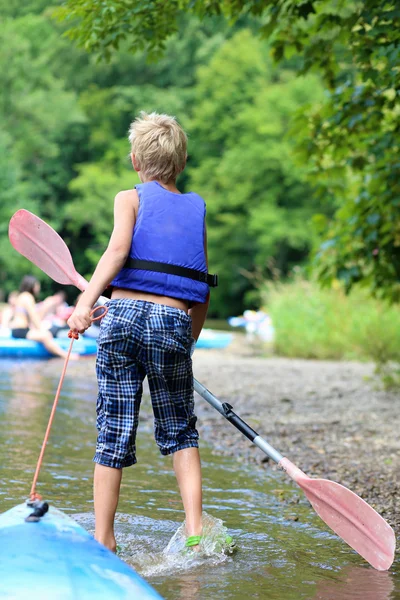 Aktiva glad tonårspojke paddling på floden — Stockfoto