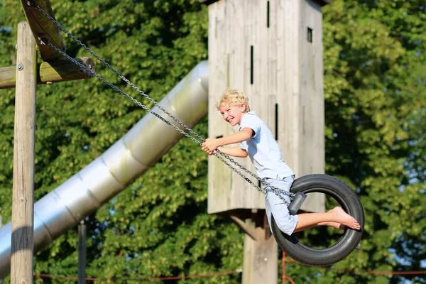 Gelukkige jongen swingen in het park — Stockfoto