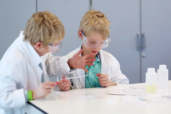 Dos escolares durante la clase de química en el laboratorio — Foto de Stock