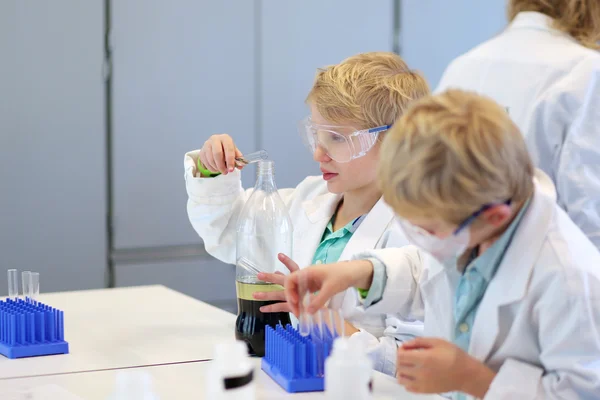 Dos escolares durante la clase de química en el laboratorio — Foto de Stock