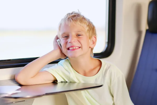 Jonge jongen reizen met de trein praten op mobiele telefoon — Stockfoto