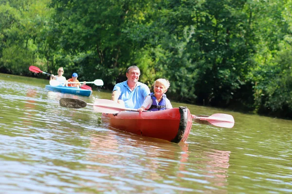 Far och son paddling på floden — Stockfoto