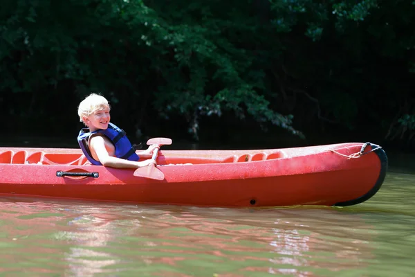 积极快乐十几岁的男孩在河上划独木舟 — 图库照片